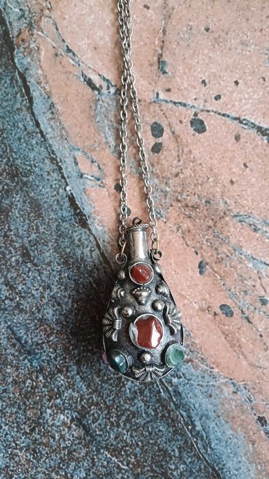 Старинно колие е флакон за парфюм  изработено от метал с декорация от камъни.