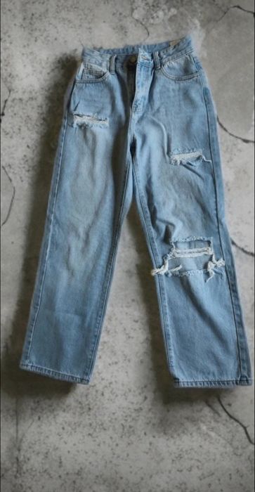 Blugi damă tip straight fit, talie înaltă, denim, preț negociabil albastru deschis. Model modern cu rupturi decorative în zona genunchilor.