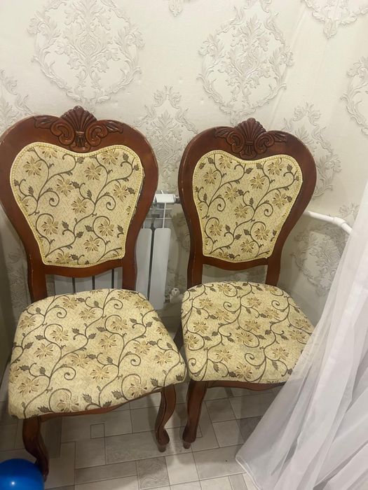 Стулья выполнены из тёмного лакированного дерева с изогнутыми ножками.