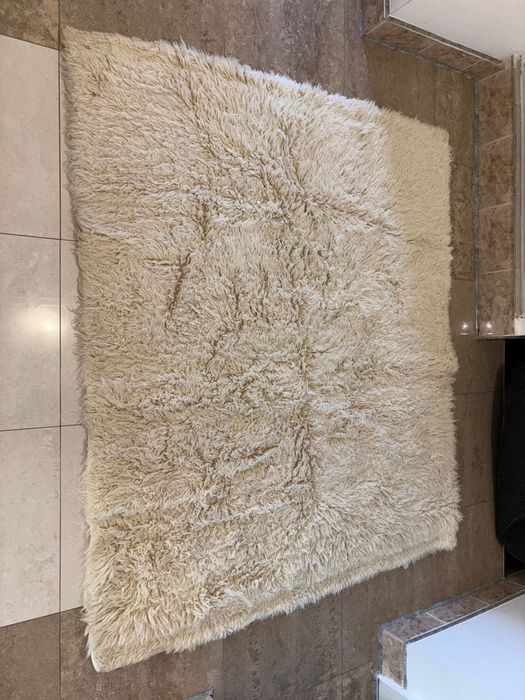 Бял пухкав килим от естествена овча кожа – отлично запазен.