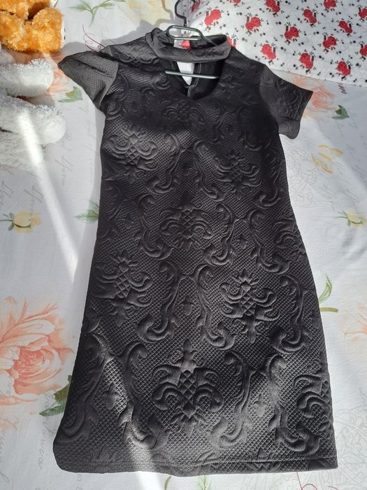 Rochie neagra cu fermoar pe spate.