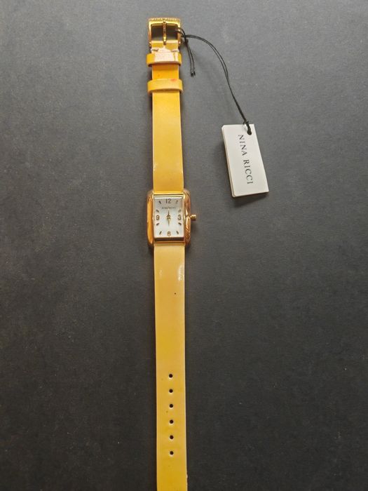 Ceas de dama Nina Ricci  auriu cu cadran alb original, nou  fără cutie