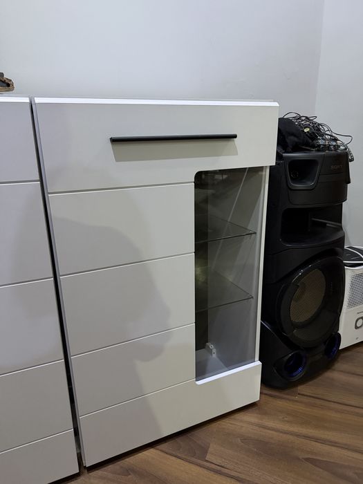Продавам модерен бял шкаф с опушена стъклена витрина и стъклени рафтове