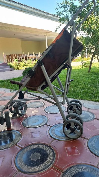 Коляска-трость, легкая и компактная модель, удобная для прогулок.