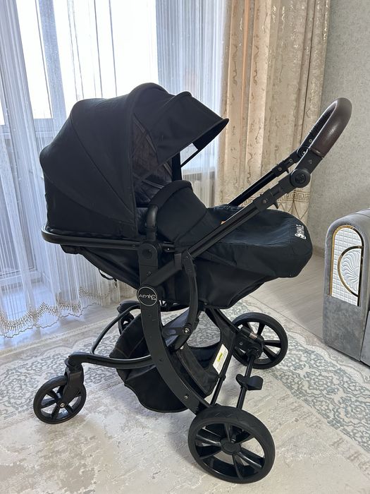 Продаётся современная детская коляска в чёрном цвете.