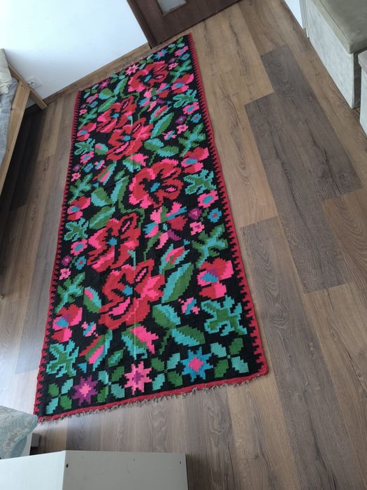 Covor tradițional românesc țesut manual model floral cu trandafiri.