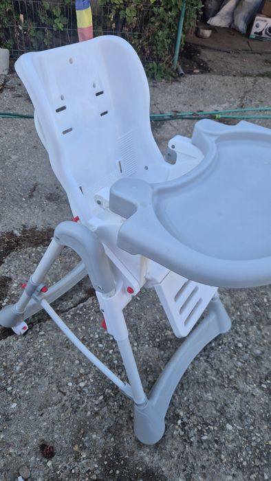 scaun de masă pliabil pentru copii, realizat din plastic alb și gri, cu cadru metalic
