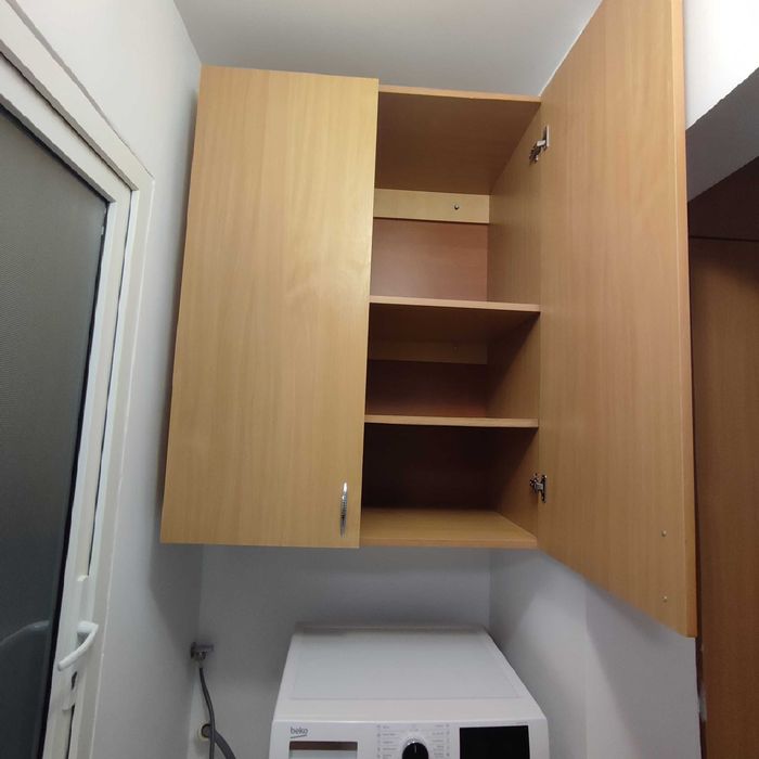 Dulap suspendat deasupra mașini de spălat.