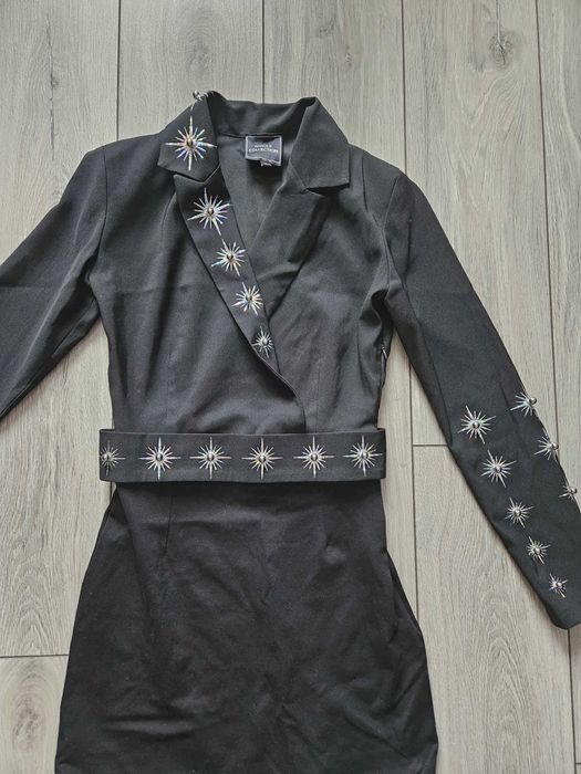 Елегантна черна рокля с декоративни елементи.