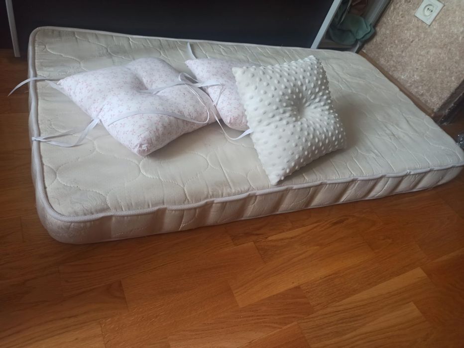 Детская кровать с матрасом и подушками.