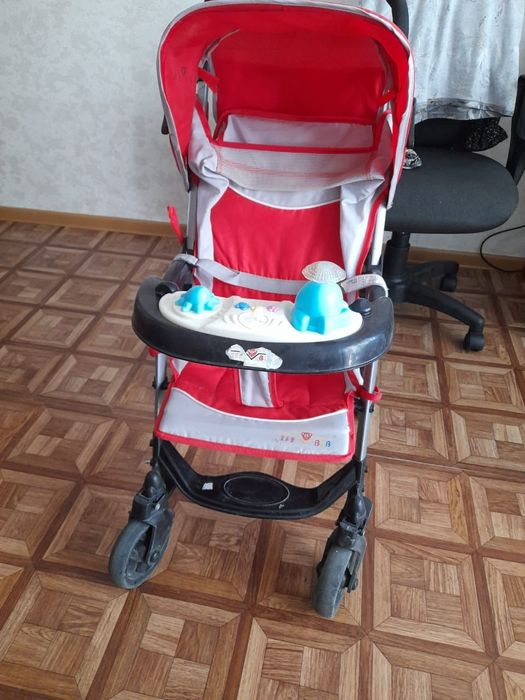 Детская коляска красного цвета