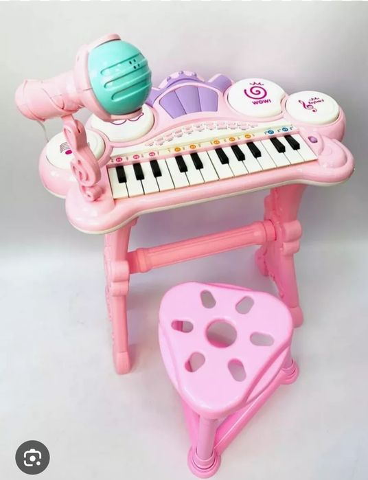 детское электронное пианино розового цвета с микрофоном и стульчиком.