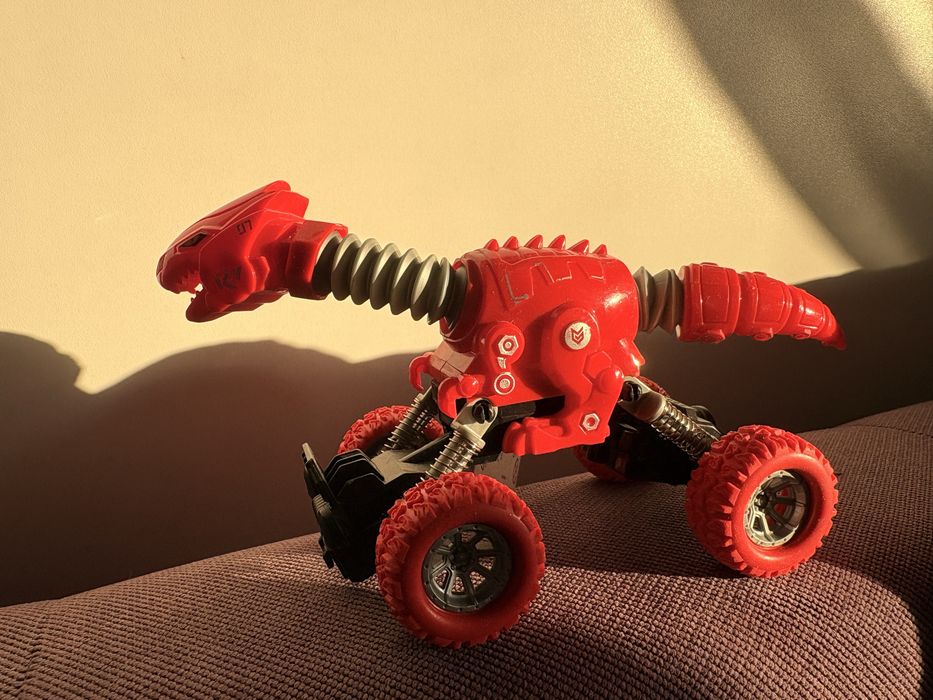 Mașinuță dinozaur roșie cu roți mari