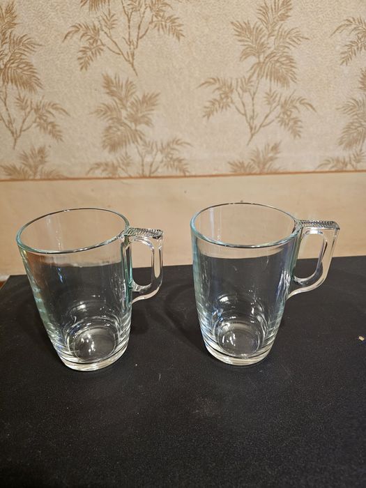 Кружки из стекла и тарелки фаянсовые.