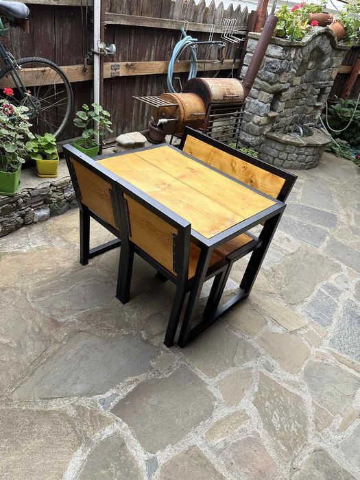 Градиндка маса с пейка и столове от дърво и метал.