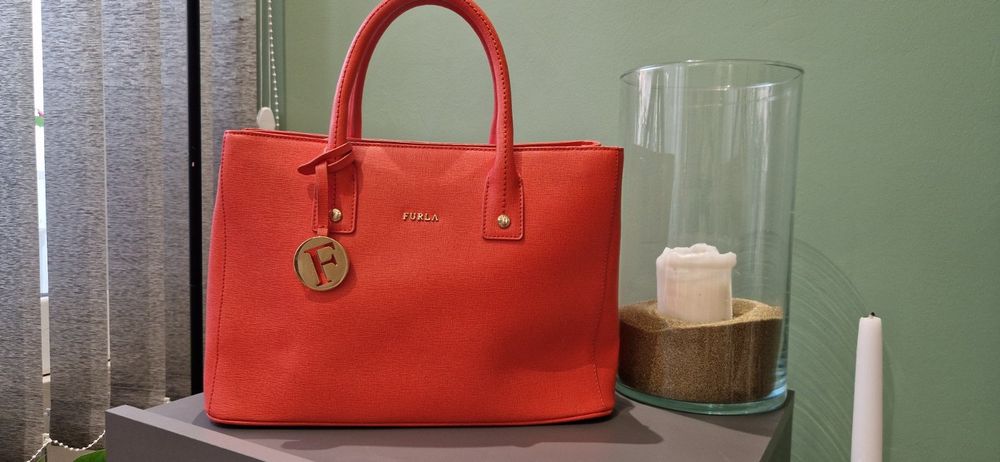 Чанта FURLA Linda S Tote, Ruby
Носена е няколко пъти,но е малко по-голяма от колкото очаквах.
 Размери:31×22.5-23×13-14 cm
Цената е 60 €