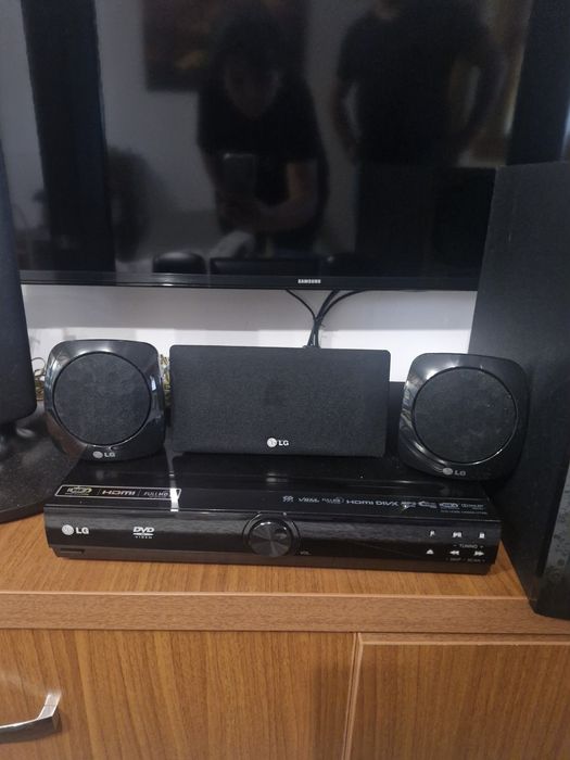 SIstem Home Cinema LG 5.1 compus din boxe verticale de tip tallboy, un subwoofer, o boxă centrală, două boxe satelit mici poziționate pe unitate