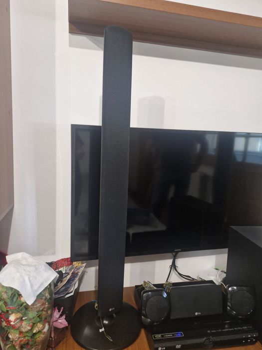 SIstem Home Cinema LG 5.1 compus din boxe verticale de tip tallboy, un subwoofer, o boxă centrală, două boxe satelit mici poziționate pe unitate