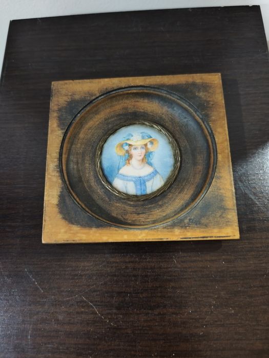 Миниатюрен портрет в рамка, върху по-голяма, дълбока дървена основа.