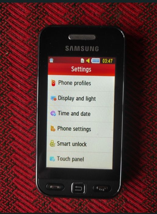 Telefon cu touchscreen și cameră, foarte mic, robust, ocupă puțin spațiu și foarte practic.