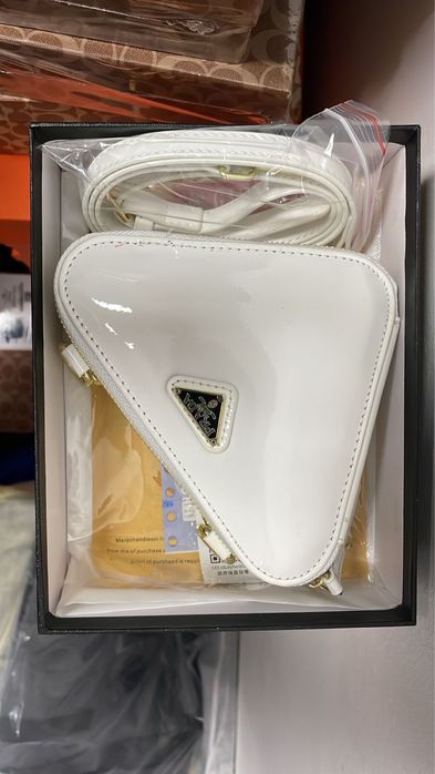 стильная мини-сумка в форме треугольника от бренда Prada.