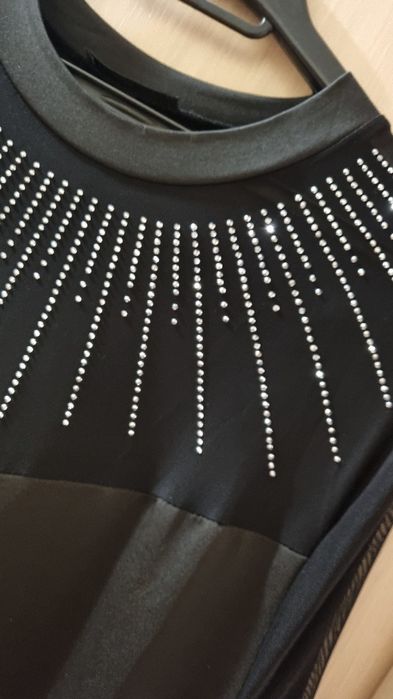 Рокля с мрежест детайл на деколтето и ръкавите, гарниран с камъчета.