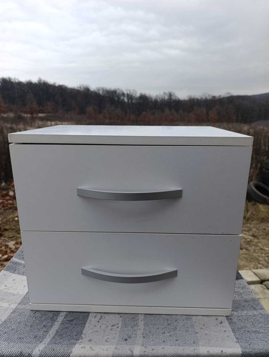 Vând set de două noptiere cu picioare, fiecare dotată cu două sertare.