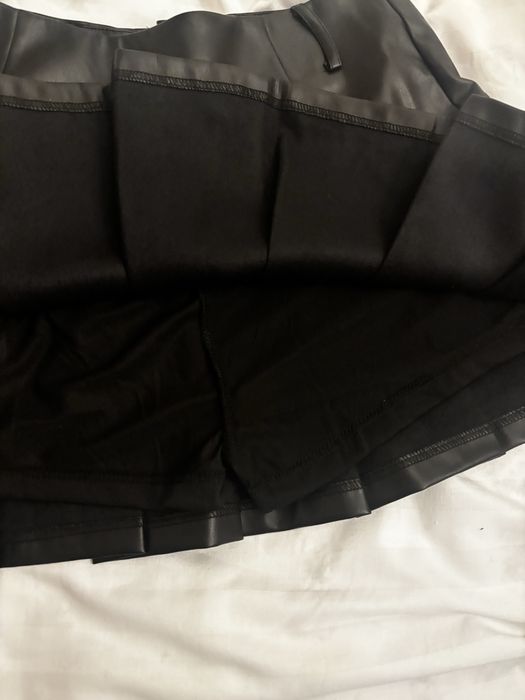 Fustă neagră scurtă din piele cu pantaloni pe dedesubt