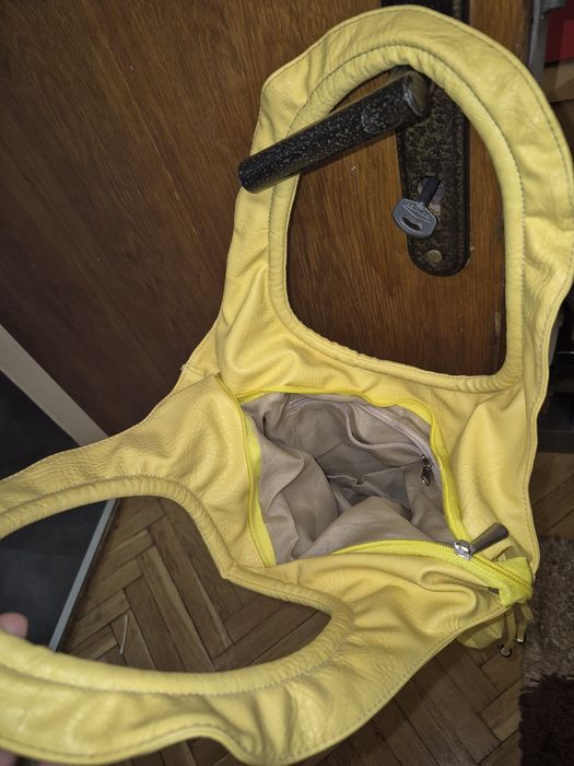 Жълта чанта с цип, вътрешен джоб и връзки за ефектно пристягане .