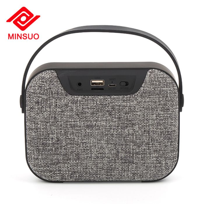 Блутут колонка говорител с текстилна обвивка и гумирана дръжка.