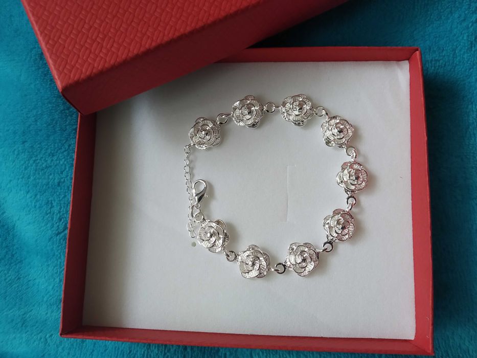 Нова, масивна сребърна гривна с рози. Поставена в кутия за подарък.