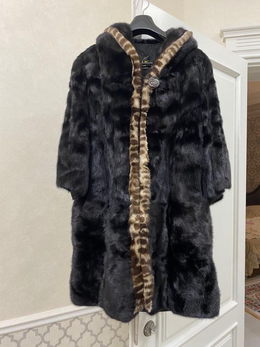 Женская шуба, длина примерно до колена, средняя.