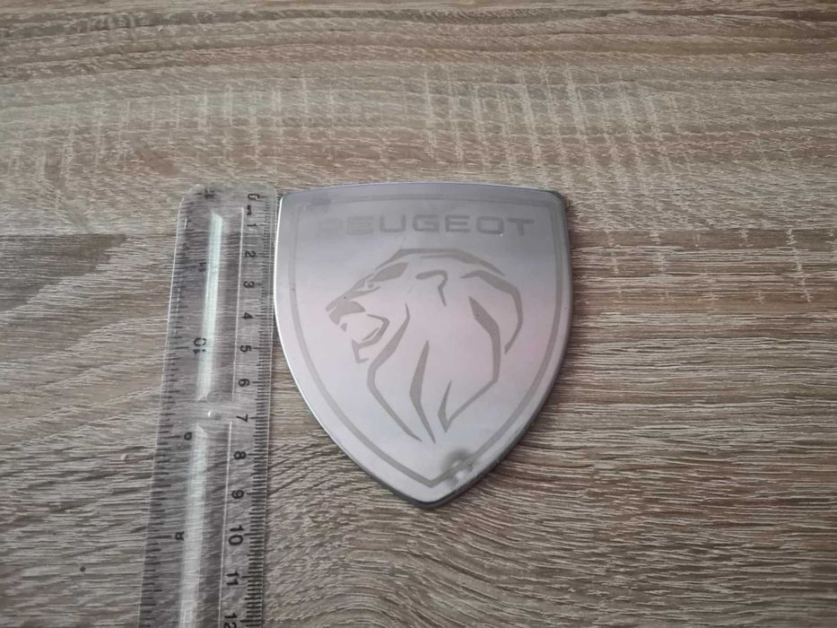 бяла метална емблема Peugeot с новото лого