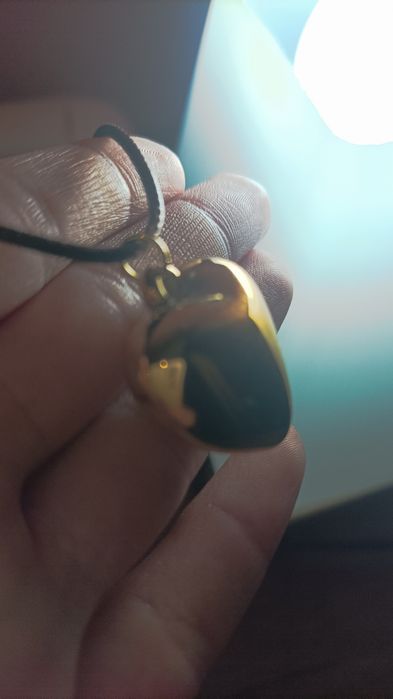 Гердан със лъскаво жълто сърце.