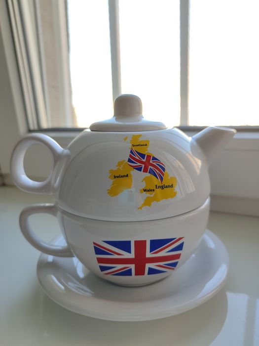 Заварочный чайник с чашкой и блюдцем