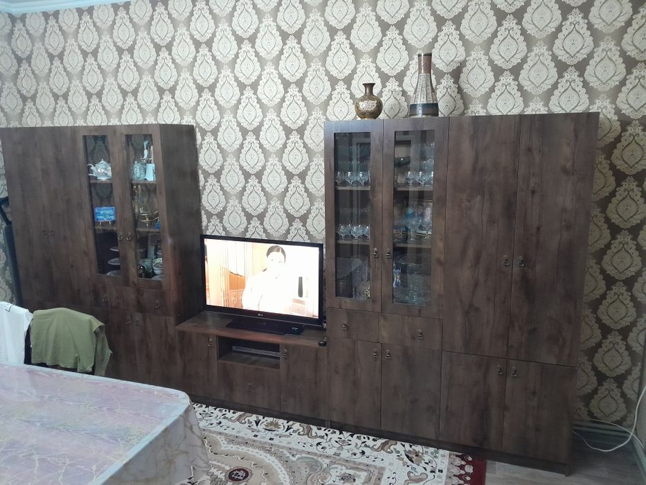 Компактная и стильная мебельная стенка для гостиной месте с телевизоро