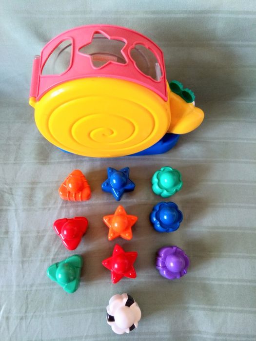 Люлеещ се музикален охлюв със сортиране по форми и цветове -6+ месеца