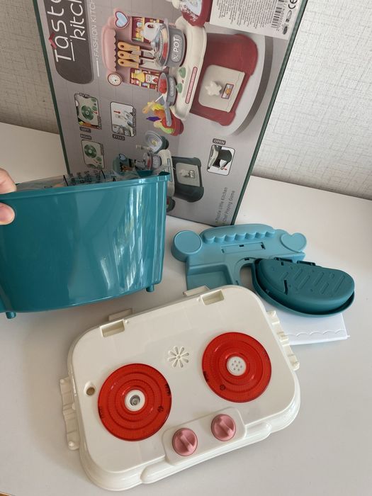 Малка зелена кухня със светещи котлони, пара и мивка с вода