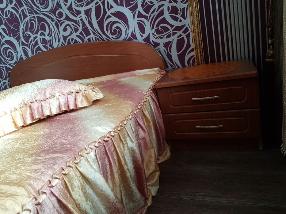 Двухспальная кровать с тумбочки.