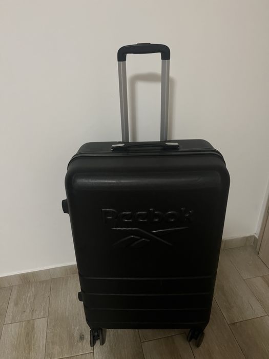 Troler Reebok negru, carcasă rigidă, 4 roți, mâner telescopic și cifru
