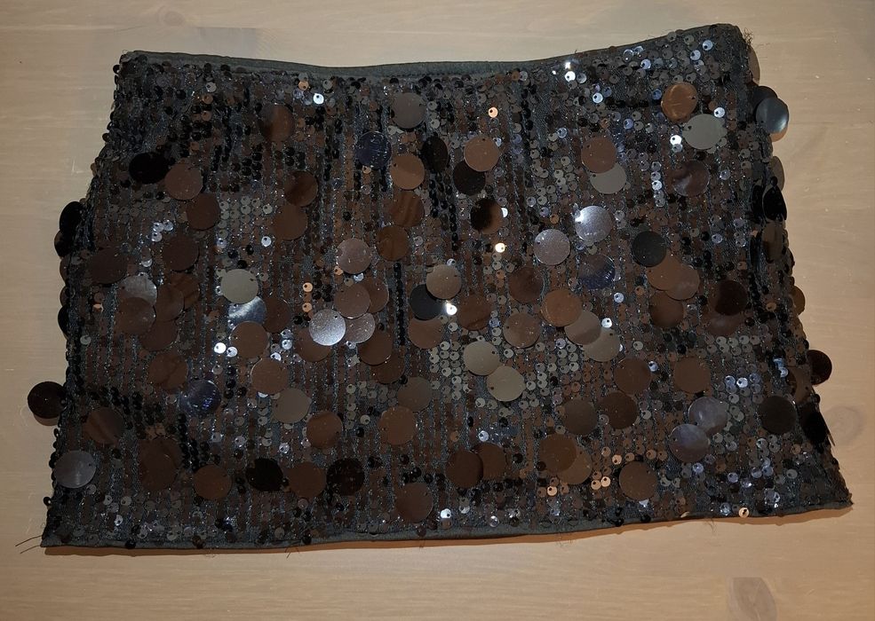 Fusta mini cu peiete, neagra, cu pantaloni scurti pe dedesubt.