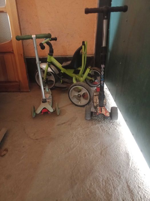 Детский велосипед, самокаты и дверь  деревяный