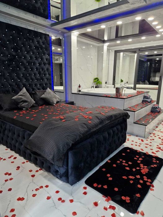 Regim hotelier cu jacuzzi in camera, oglinda deasupra patului