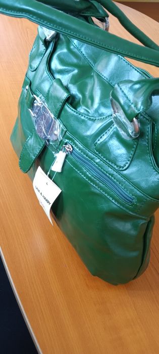 Дамска чанта от зелена еко кожа с къса и с дълга дръжка и ефектна катарама.Разпределението вътре е от две отделения и преграда с цип в средата