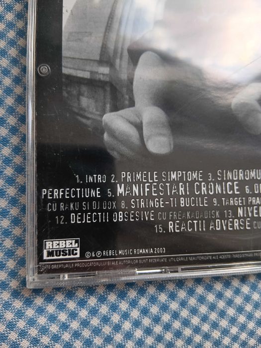 CD Cheloo, intitulat „Sindromul Tourette”, lansat în 2003 prin casa de discuri Rebel Music, Muzica Hip Hop Romanesc