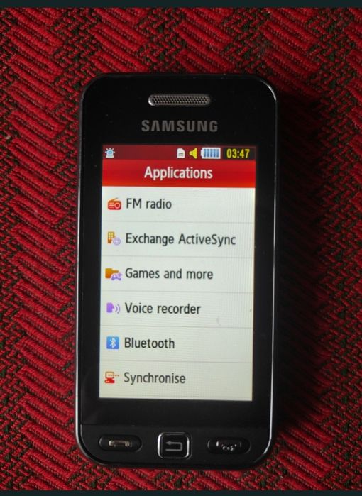 Telefon cu touchscreen și cameră, foarte mic, robust, ocupă puțin spațiu și foarte practic.