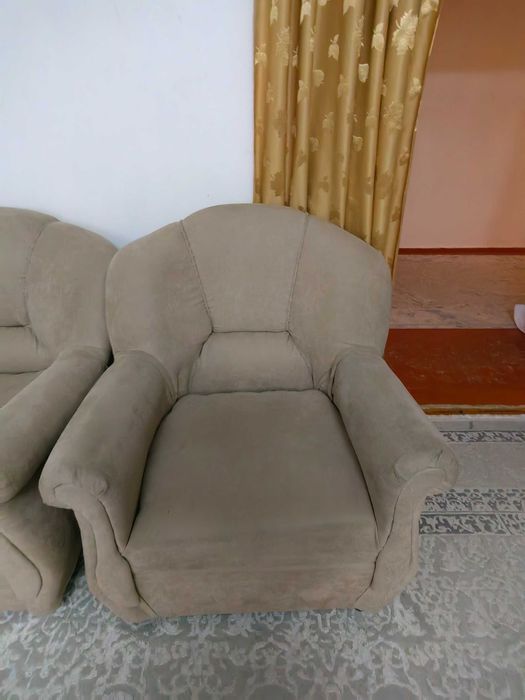 Диван уголок, два кресла и книжный шкаф.