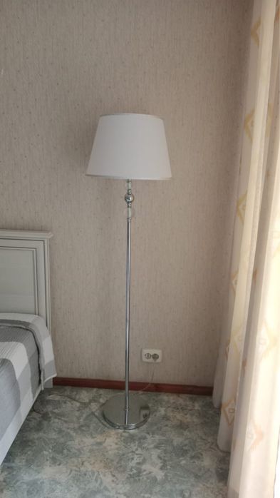 Торшер белого цвета светит теплым цветом