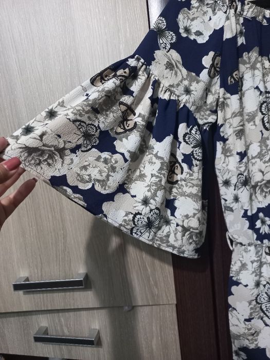 Salopeta cu pantalon evazat,  elegantă, cu maneci largi și decorațiune cu paiete.