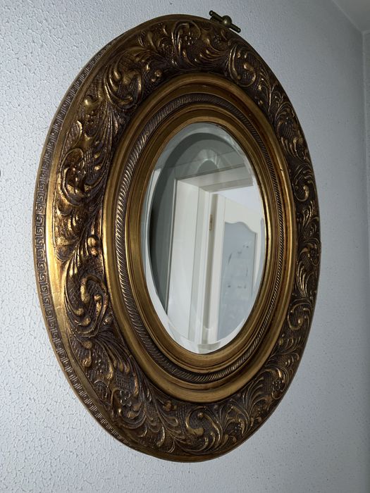 Oglindă ovală decorativă cu ramă aurie sculptată stil baroc (bizotată)